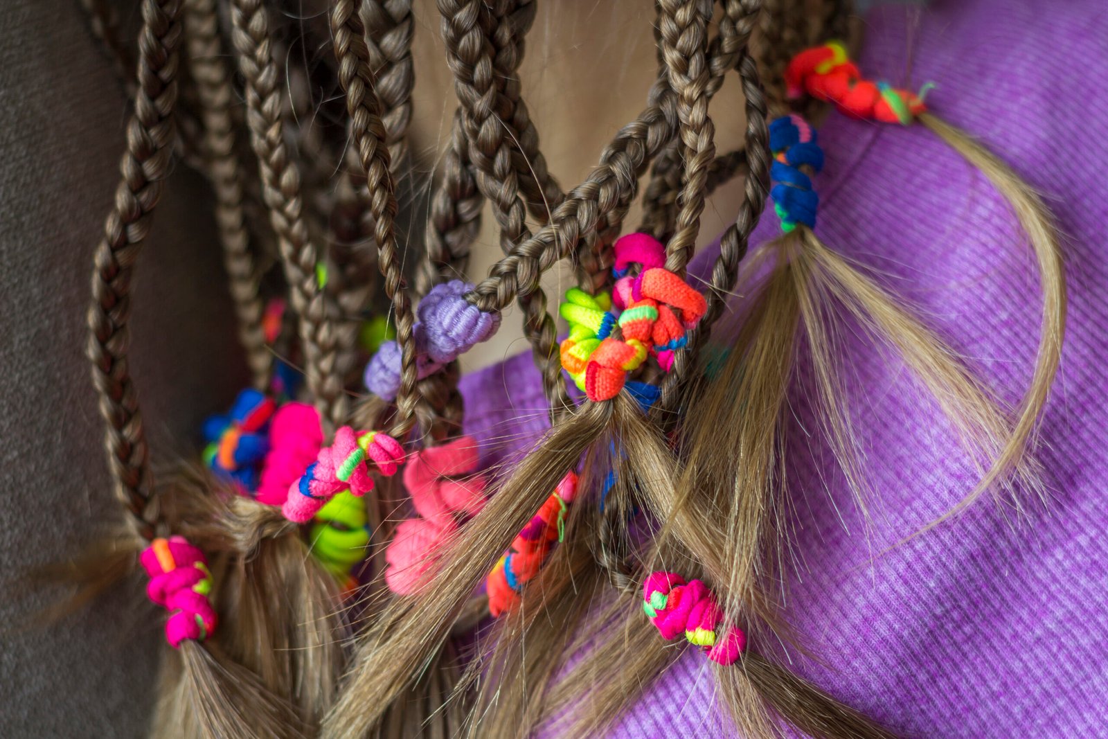 Close up of braid hair of little girl with colorful rubber bands
